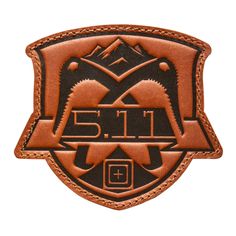 a leather patch with the number 511 on it and mountains in the back ground