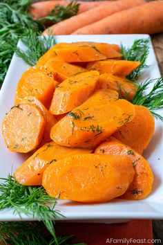 sliced carrots with herbs on a white plate