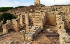 the ruins of an ancient city with a clock tower in the background