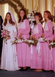 a group of women in pink dresses standing next to each other with bouquets and flowers