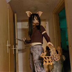 a woman with long black hair wearing an animal mask and holding a knife in her hand