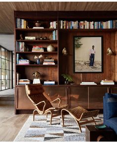 a living room filled with furniture and bookshelves next to a wall mounted tv