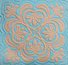 a blue and white quilt with an intricate design on it's center piece is shown