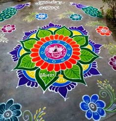 a colorful flower design is painted on the ground