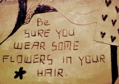 graffiti written on the side of a building that says be sure you wear some flowers in your hair