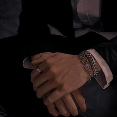 a man in a tuxedo is holding his hands together