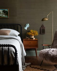 a bedroom with a bed, desk and chair in it's corner next to a window