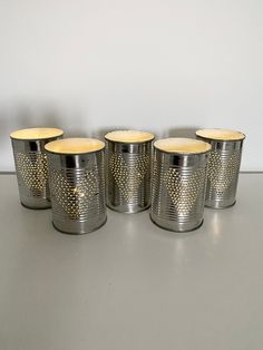 four silver canisters with gold dots on them