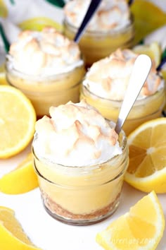 lemon meringue pie in mason jars topped with whipped cream and sliced lemons