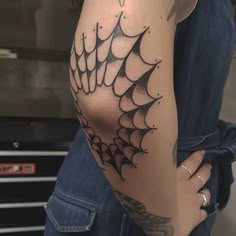 a woman with a spider web tattoo on her arm