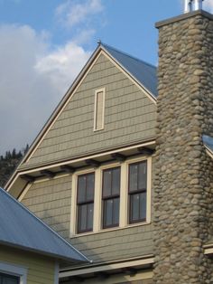 a house with two windows and a clock on the front of it's tower