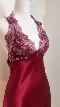 Burgundy and pink lace halter slip dress with a beautiful lace bodice and a beautiful bow detail on the front. It has a beautiful lace pattern on the bodice and a satin slip underneath. Lace Camisole With Lace Closure For Party, Party Lace Camisole With Lace Closure, Party Camisole With Contrast Lace And Spaghetti Straps, Elegant Party Camisole With Contrast Lace, Elegant Party Camisole With Lace Closure, Evening Lace Camisole With Lace Trim, Feminine Lace Camisole For Party, Elegant Lace Camisole With Lace Back, Elegant Lace Camisole With Lace Closure