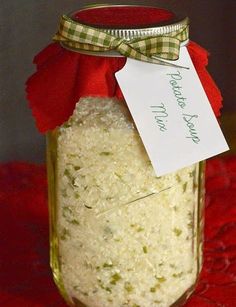 a jar filled with white rice sitting on top of a red table cloth next to a tag