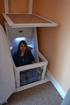 a woman sitting in a small space between two beds