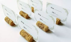 four wine cork place cards with labels on them are lined up in rows and placed next to each other