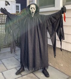 a man dressed in a ghost costume standing outside