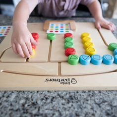 a young child playing with wooden toys on the floor