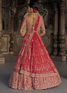 Embrace the elegance with this stunning Red Silk Embroidered Bridal Lehenga Set, designed to exude timeless beauty for the modern bride. Crafted from premium raw silk , the vibrant red lehenga is intricately adorned with gold Kasab embroidery, enhanced with delicate resham french knots, patras, dabka, beads, and shimmering sequins. Paired with an exquisitely embellished blouse and a soft net dupatta, the set radiates ethereal charm Perfect choice for brides on their special day. Additionally, a gold tissue stripe booti dupatta can be ordered separately as a graceful head veil, along with a detailed worked belt to complete the ensemble. Composition : Lehenga, Blouse - Raw Silk and Dupatta - Soft Net Care: Dry Clean Only and Vacuum Storage This product can be customized for sleeves, blouse l Designer Red Meenakari Choli, Red Meenakari Choli For Reception, Designer Red Meenakari Lehenga, Red Meenakari Lehenga For Reception, Red Meenakari Lehenga For Wedding, Red Choli With Meenakari And Kundan, Fitted Red Lehenga With Meenakari Details, Tassel Blouse, Anamika Khanna