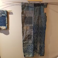 two pieces of cloth hanging on a clothes line next to each other in a room