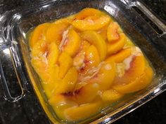 sliced peaches are in a glass dish on the counter