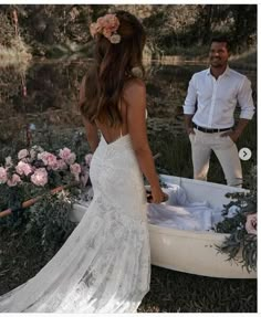 a woman in a wedding dress standing next to a man