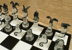 a black and white chess board with silver pieces