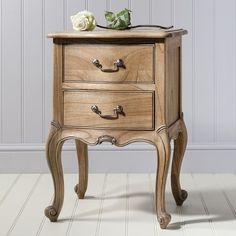 a wooden table with two drawers and a white rose on the top one drawer is turned upside down