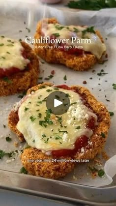 crab cakes with sauce and parmesan cheese are on a baking sheet, ready to be cooked