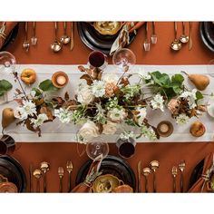 an overhead view of a table setting with plates, silverware and flowers on it