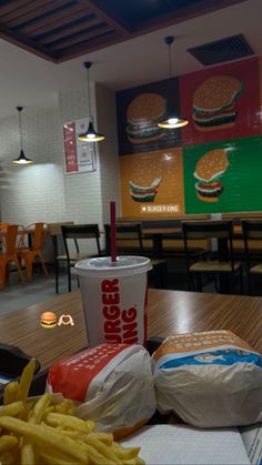 a tray with french fries and a cup of soda sitting on a table in a fast food restaurant