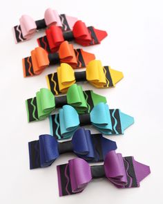 several different colored bows are lined up on a white surface