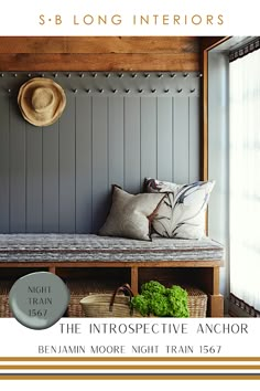 a bench with pillows and hats on it in front of a gray paneled wall