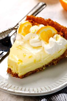 a slice of cheesecake with oranges and whipped cream on top sits on a plate