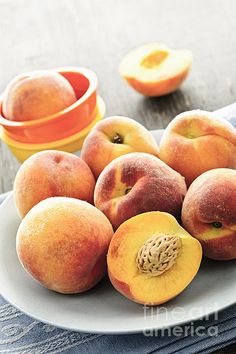 a white plate topped with peaches next to an orange