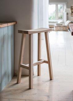 a wooden stool sitting in the middle of a room