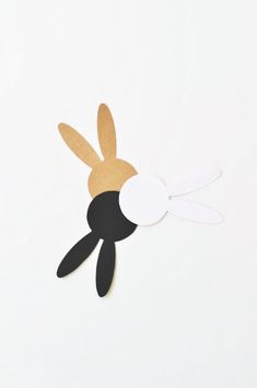 an animal made out of paper on a white surface with the shape of a rabbit's head