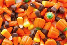 there are many candy candies on the table together and one is orange, brown, yellow and green