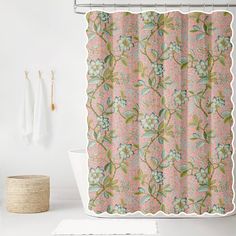 the shower curtain is decorated with pink and green floral designs, along with a white bathtub