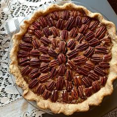 a pecan pie sitting on top of a table next to a lace doily