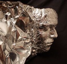 a silver foil wrapped sculpture of a man's head