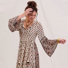 Step into boho bliss with the Julia Ecru & Black Bohemian Tiered Dress! Made from a dreamy blend of 50% modal and 50% viscose, this dress drapes beautifully for a flattering, comfortable fit. The playful full-length bell sleeves add a touch of elegance, while the open neck design keeps your look effortlessly chic. Fall in love with the unique details, like the long decorative tassels with cute accents and the contrasting design on the sleeves and bottom of the dress. With its ankle-length flow, Flowy Bohemian Midi Dress For Fall, Flowy Boho Print Midi Dress In Rayon, Flowy Bohemian Boho Dress For Fall, Fall Bohemian Flowy Boho Dress, Flowy Bohemian Brown Midi Dress, Boho Print Midi Dress In Rayon, Bohemian Flowy Tunic Boho Dress, Chic Flowy Rayon Boho Dress, Cream Bohemian Midi Dress