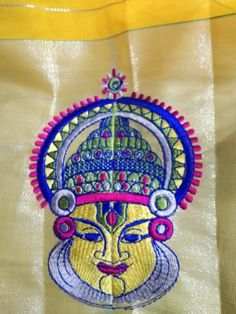 an embroidered design on the side of a white bag with yellow and blue trims