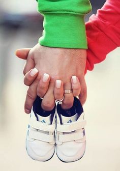 two people holding hands while wearing white shoes