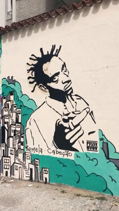 a mural on the side of a building depicts a man with dreadlocks and a cityscape