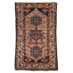 an antique persian rug with blue, red and orange colors on the bottom half of it