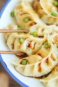 some food is sitting on a plate with chopsticks in it and sauce drizzled over the top