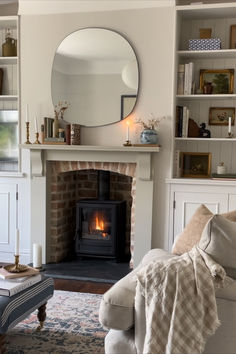 a living room filled with furniture and a fire place next to a mirror on the wall