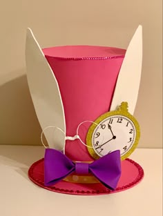 a pink top hat with a clock on the side and purple bow tie around it