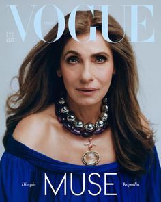 a woman with long hair wearing a blue dress and necklace on the cover of a magazine