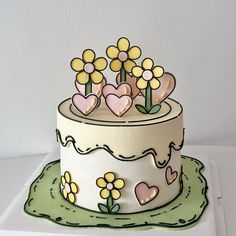 a white cake with yellow flowers and hearts on it